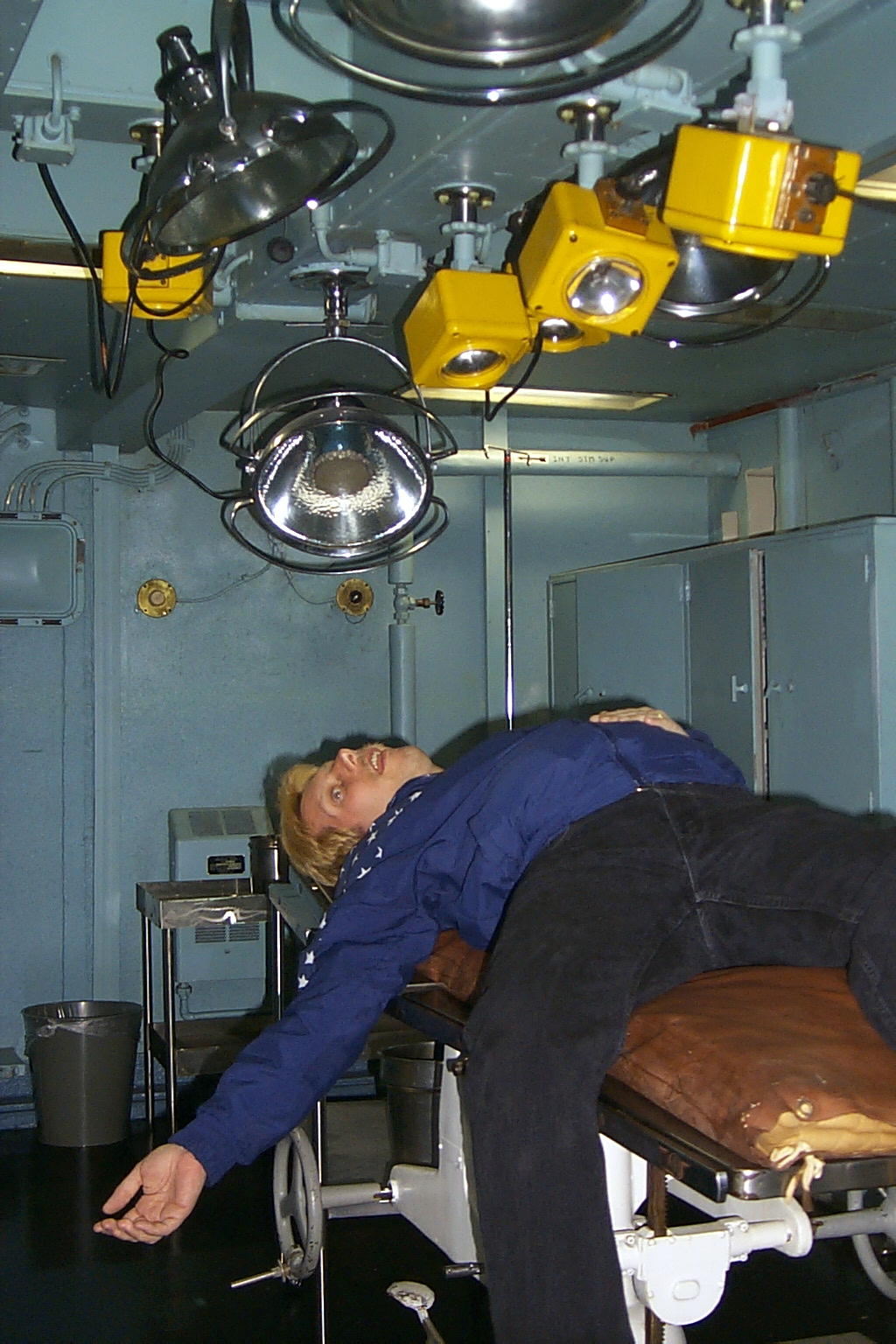 Dennis is passed out on the operating table in Sick Bay from running up and down the ladders aboard the ship.